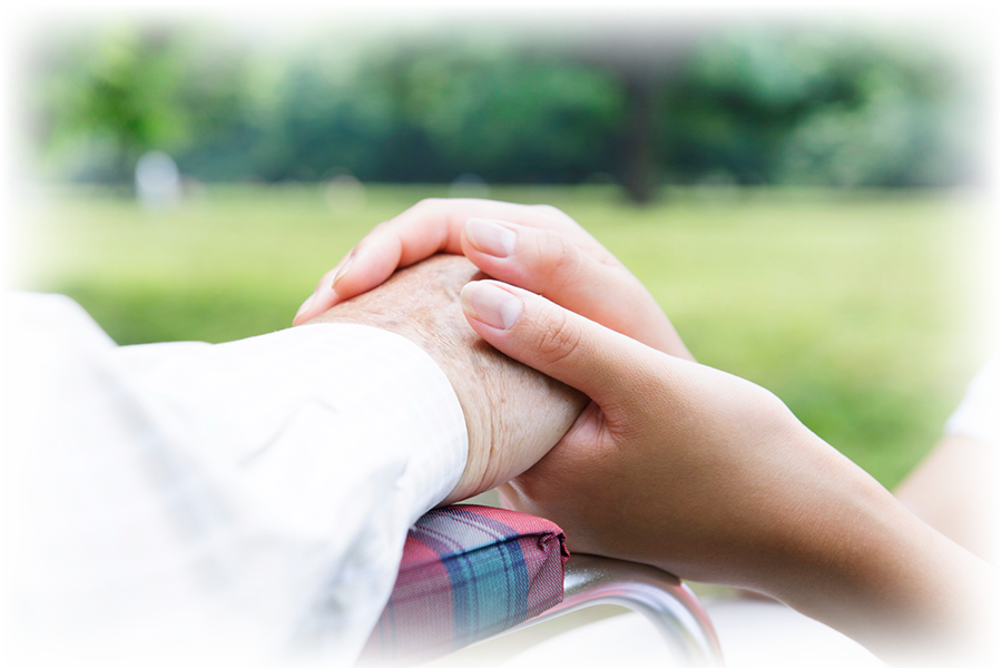 高齢者の右手を両手で握る様子